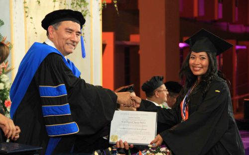 Rector de la UTP entrega diplomas a graduandos.