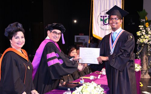 Graduando recibe Diploma de manos del Rector de la UTP.