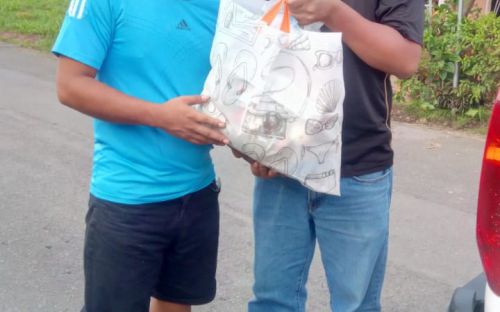 Personal del Centro Regional de Bocas del Toro, entrega bolsa de alimento a estudiante.