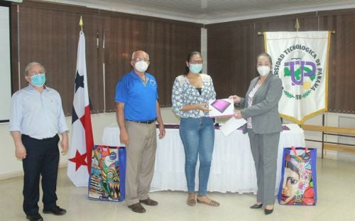 Ing. Vivian Valenzuela, Vicerrectora de Vida Universitaria de la UTP, entrega tablet a estudiante.