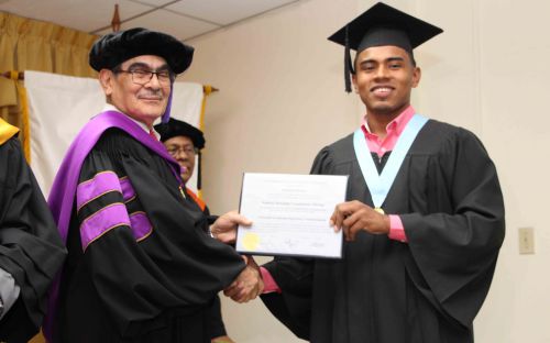 Rector de la UTP entrega Diplomas de graduación a estudiante.
