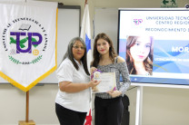 Mgtr. Cecilia González entregando el certificado a una estudiante del capítulo de honor