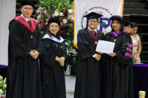 Estudiante recibiendo su diploma de manos de la Rectora.