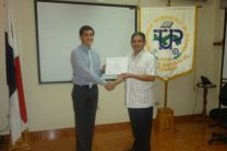 El Dirctor, Amílcar Díaz,  entrega  certificado al estudiante Daniel Acosta.