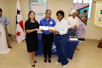 Entrega de Carnets y Certificado a participante por parte de Licenciada Evet Clachar, directora del Centro Regional de Colón y Stephanie Lezcano, Fundación AES Panamá.