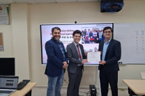 Reconocimiento a estudiante de la FISC Jesús De Gracia de la FISC recibe su certificado del Ing. Paulo Picota frente a la pantalla interactiva.