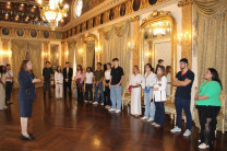 Charla histórica de la Licenciada Nora Delgado en el Salón Amarillo. Guía del palacio explicando la historia panameña ante la delegación universitaria en un salón formal.