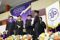 Rector de la UTP hace entrega de diploma a graduando.