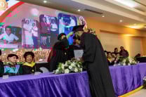 Autoridades realizan cambio de birrete durante una graduación a los estudiantes.