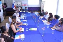 Asistentes a la Rueda de prensa alrededor de una mesa con mantel azul.