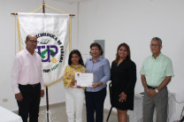 Licda. Lesbia Ramos, Secretaria Académica entrega certificado de Menciones Honoríficas a estudiante 