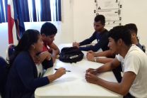 Estudiantes reunidos en mesa de trabajo durante taller de liderazgo.
