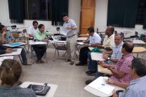 Lic. José Peralta Corodinador de la FISC entrega horarios a un grupo de persona.