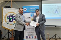 El Dr. Omar López Alfano, expositor de la conferencia, recibe certificado de participación de manos del director del CINEMI, Dr. Félix Henríquez.
