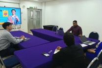 Participantes de la reunión sentados a la mesa discutiendo proyectos de movilidad.