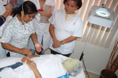 Profesora junto a alumnos enseña tecnicas de cosmetología.