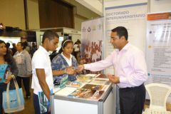 El Dr. Gabriel Vergara entrega folletos a los asistentes al stand de la UTP.