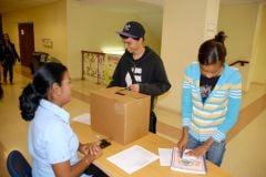 Estudiantes participan depositando sus respuestas en la urna.