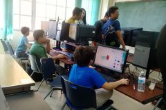 Niños frente a las computadoras diseñando para imprimir en 3D.