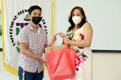 Estudiante recibe equipo tecnológico. 