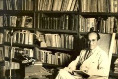 Rogelio Sinan junto a su biblioteca personal, que ahora está en las instalaciones de la UTP.