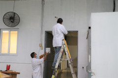 Colaboradores de la UTP pintando una pared.