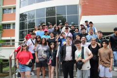 La delegación de la World Robot Olympiad (WRO) y el Dr. Felipe Mora posan frente al Edificio 3 de la UTP.