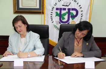 La Rectora y la representante de Tagua, firman el convenio.