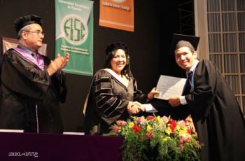 El estudiante del primer puesto de honor recibe su diploma.