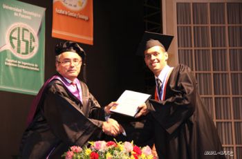 El estudiante de mayor índice académico, recibe su diploma.