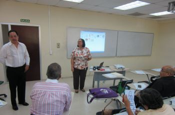 Mgtr. Ricardo López G., Decano y la Mgtr. Kaddine Lay, Experta se dirigen a los asistentes en un aula de clases..