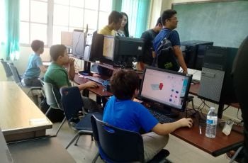 Niños frente a las computadoras diseñando para imprimir en 3D.