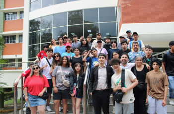 La delegación de la World Robot Olympiad (WRO) y el Dr. Felipe Mora posan frente al Edificio 3 de la UTP.
